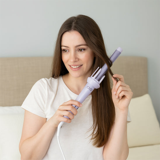 cliuente tenant boucleur et bouclant ses cheveux