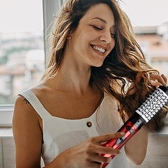 femme se bouclant les cheveux avec brosse soufflante 